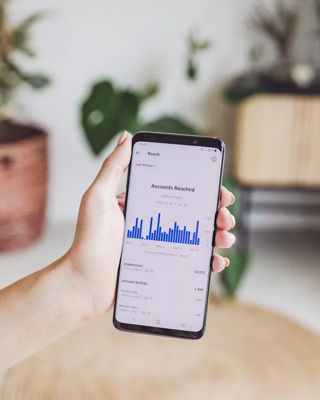 Smartphone affichant un dashboard analytics avec metriques de portee