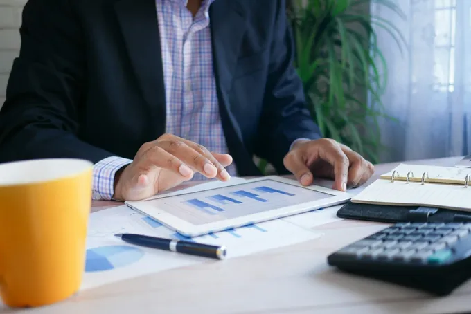 Dirigeant analysant un dashboard CRM sur tablette avec graphiques de performance